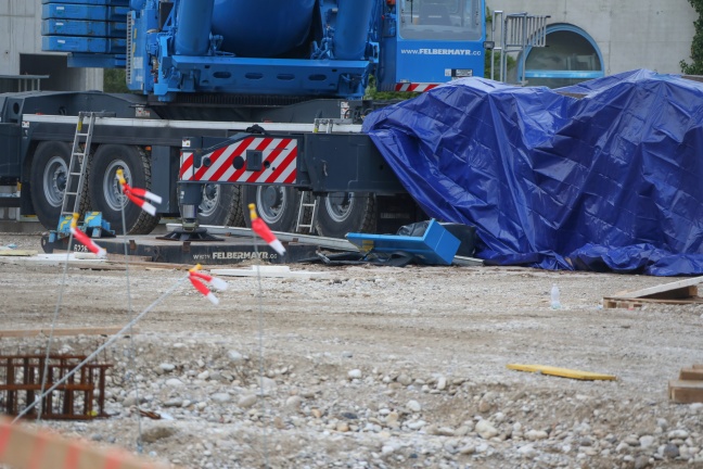 Betonsäule kracht auf Baustelle in Wels-Pernau auf Kranfahrzeug und zerquetscht Auto unter sich
