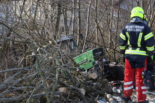 Traktor bei Waldarbeiten in Oftering über Böschung in Bach gestürzt