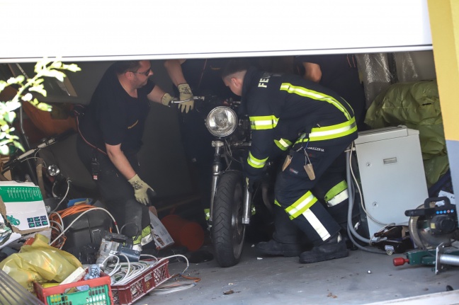 Lenker kracht in Wels-Pernau bei Unfall samt Motorrad durch Garagentor in Garage eines Wohnhauses