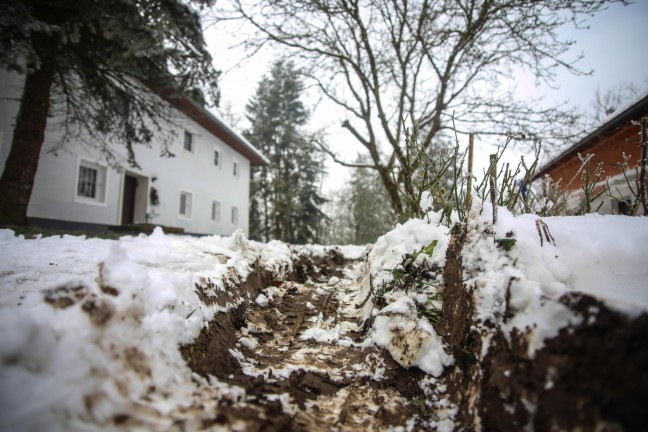 Rettungsfahrzeug bei Hofzufahrt in Marchtrenk im Schnee und Matsch festgefahren