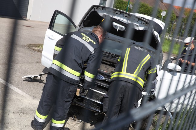 Auto bei Verkehrsunfall in Wels-Vogelweide gegen Verkehrsschilder und durch Zaun gekracht