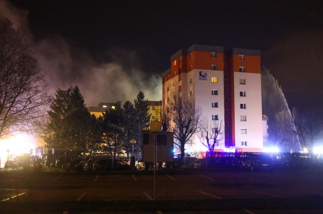 Dach einer Wohnanlage in Linz-Kleinmünchen-Auwiesen nach Wohnungsbrand in Flammen
