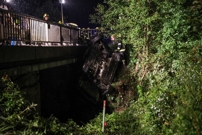 Menschenrettung: Auto landet bei schwerem Unfall überschlagen unter Brücke über den Oizingerbach