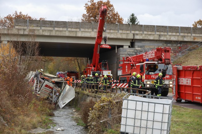 LKW-Sattelzug bei Unfall auf Westautobahn in Linz-Ebelsberg von Unterfhrung in Bach gestrzt