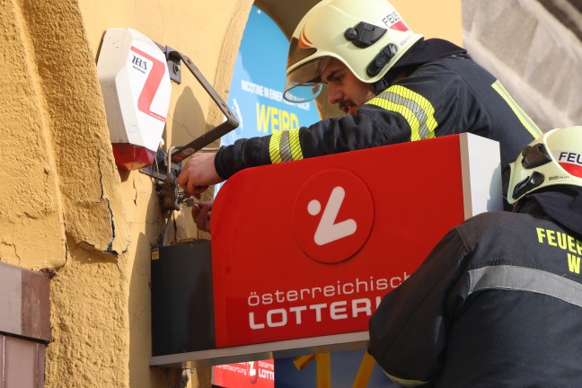 Verkehrsunfall: Besch�digte Leuchtreklamen einer Trafik in Wels-Innenstadt von Feuerwehr demontiert