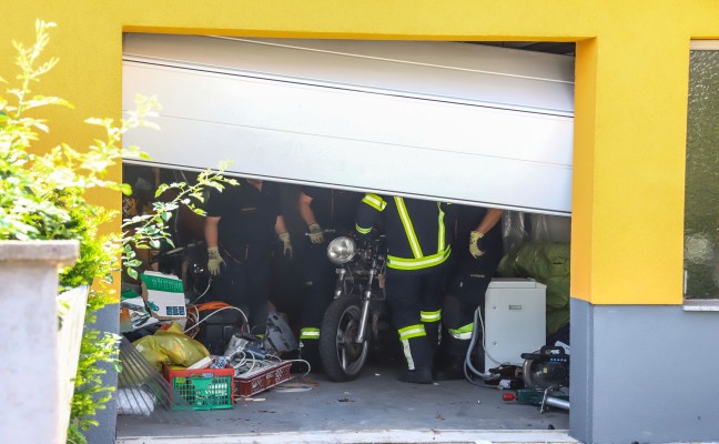 Lenker kracht in Wels-Pernau bei Unfall samt Motorrad durch Garagentor in Garage eines Wohnhauses
