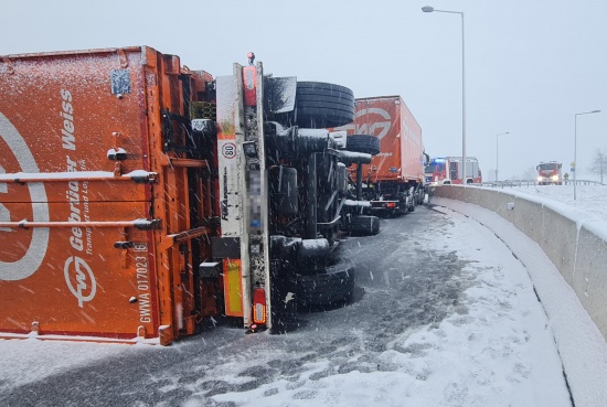 LKW-Anhänger bei winterlichen Straßenverhältnissen in einem Kreisverkehr in Freistadt umgestürzt