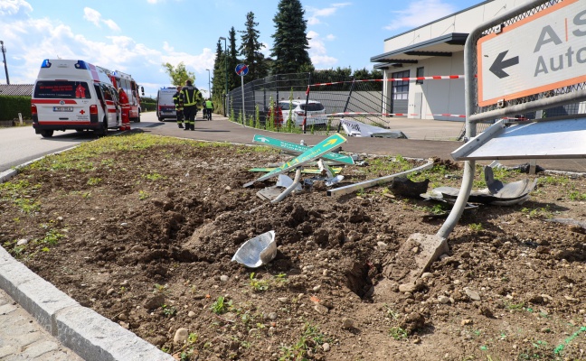 Auto bei Verkehrsunfall in Wels-Vogelweide gegen Verkehrsschilder und durch Zaun gekracht