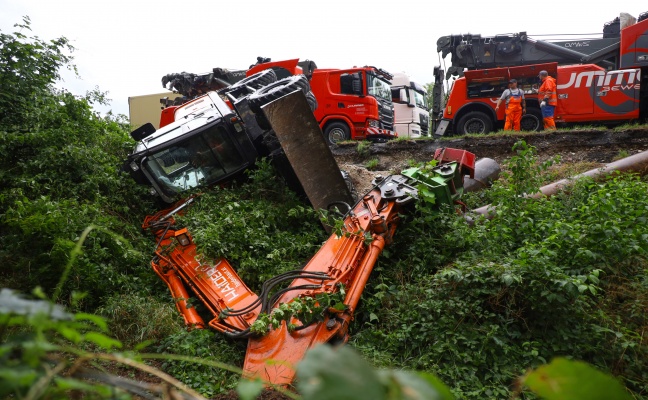 Bagger auf Baustelle auf der Welser Autobahn bei Pucking ber Bschung gestrzt